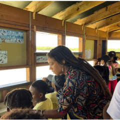 Olivia Walton stands with a group of students in a bird watching blind.