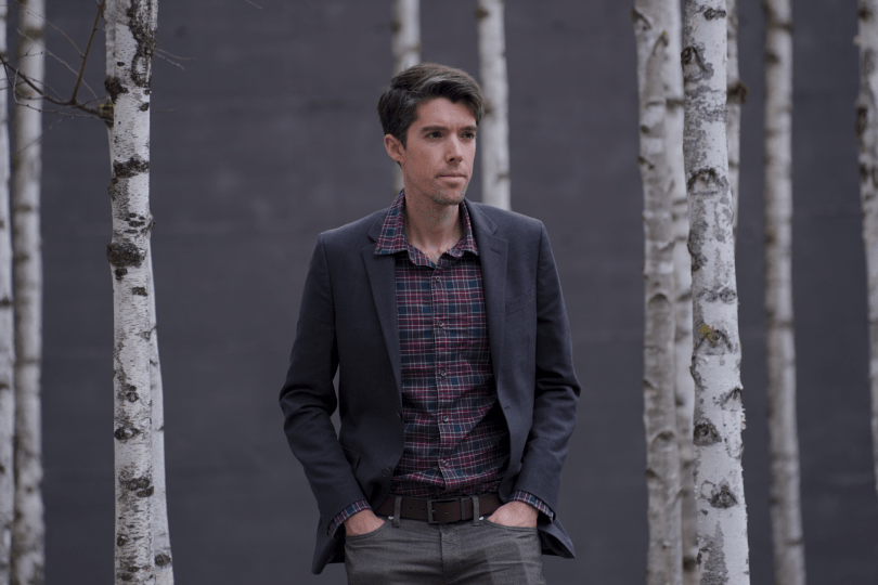 Daniel Swain stands in front of birch trees.