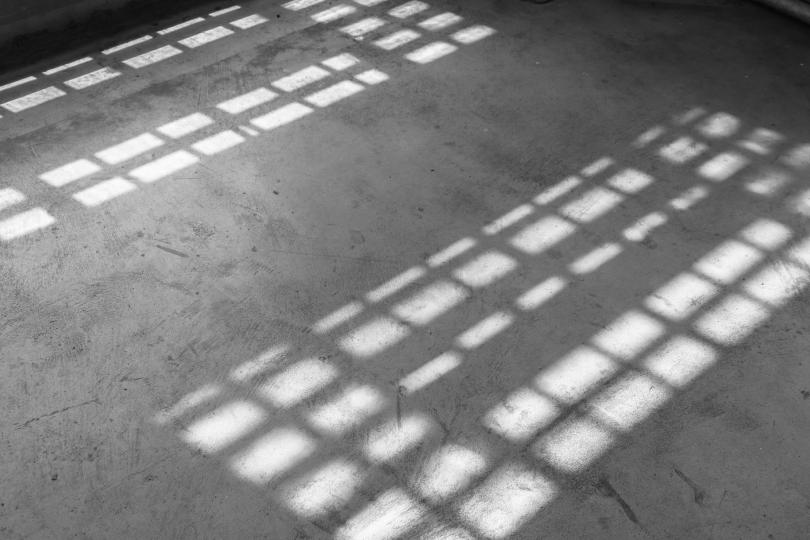 Light coming from the windows onto a concrete floor in an old building.